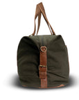 Green duffel bag with brown leather straps on a white background